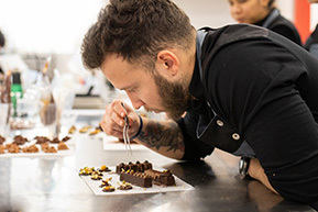 Professor cuinant amb màniga de xocolata del curs de Postres i xocolateria del Culinary Institute of Barcelona