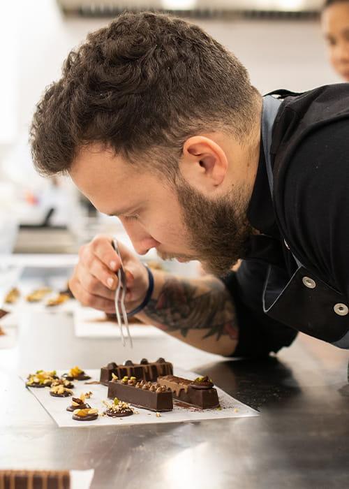 Estudiant per ser xef pastisser professional CIB Xef pastisser elaborant bombons a la cuina del Culinary Institute of Barcelona